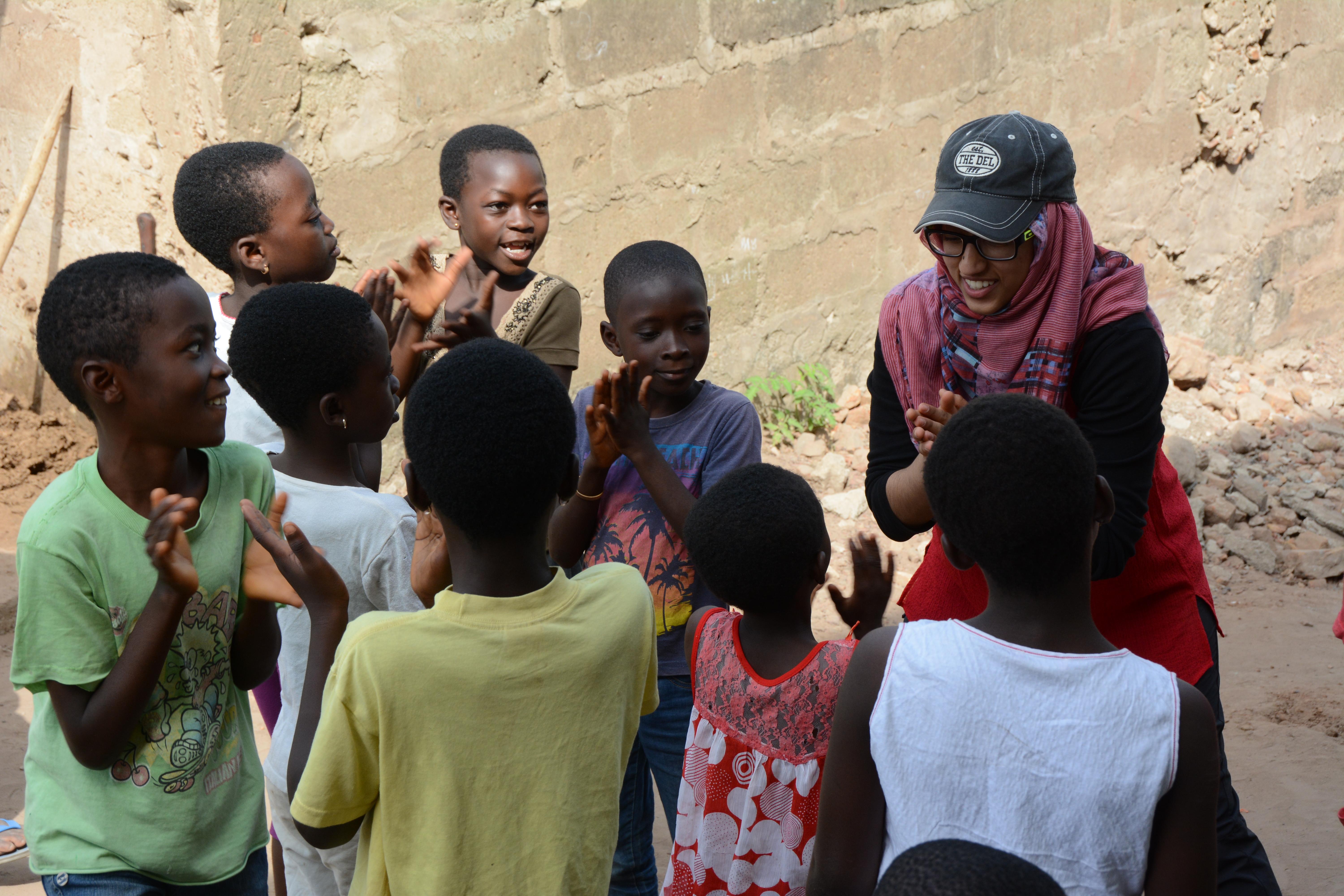 Niños e interno de Trabajo Social en Ghana realizando una actividad. Interno de Trabajo Social jugando con unos niños.